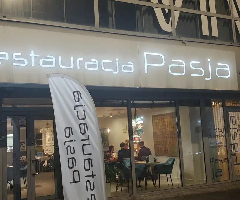 Wieczorny front Restauracji Pasja z podświetlonym napisem